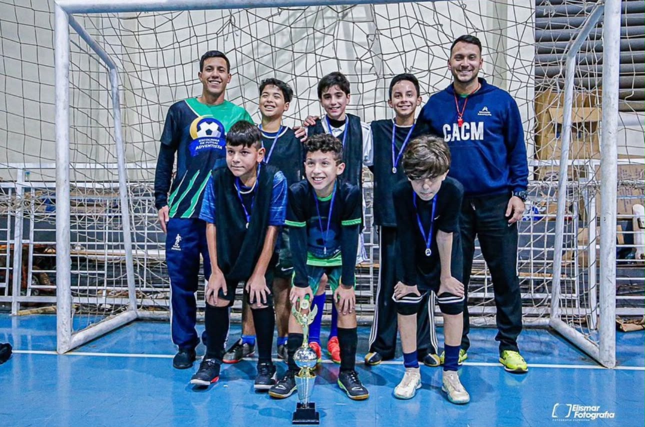 Equipe do CACM Sports celebrando com um troféu